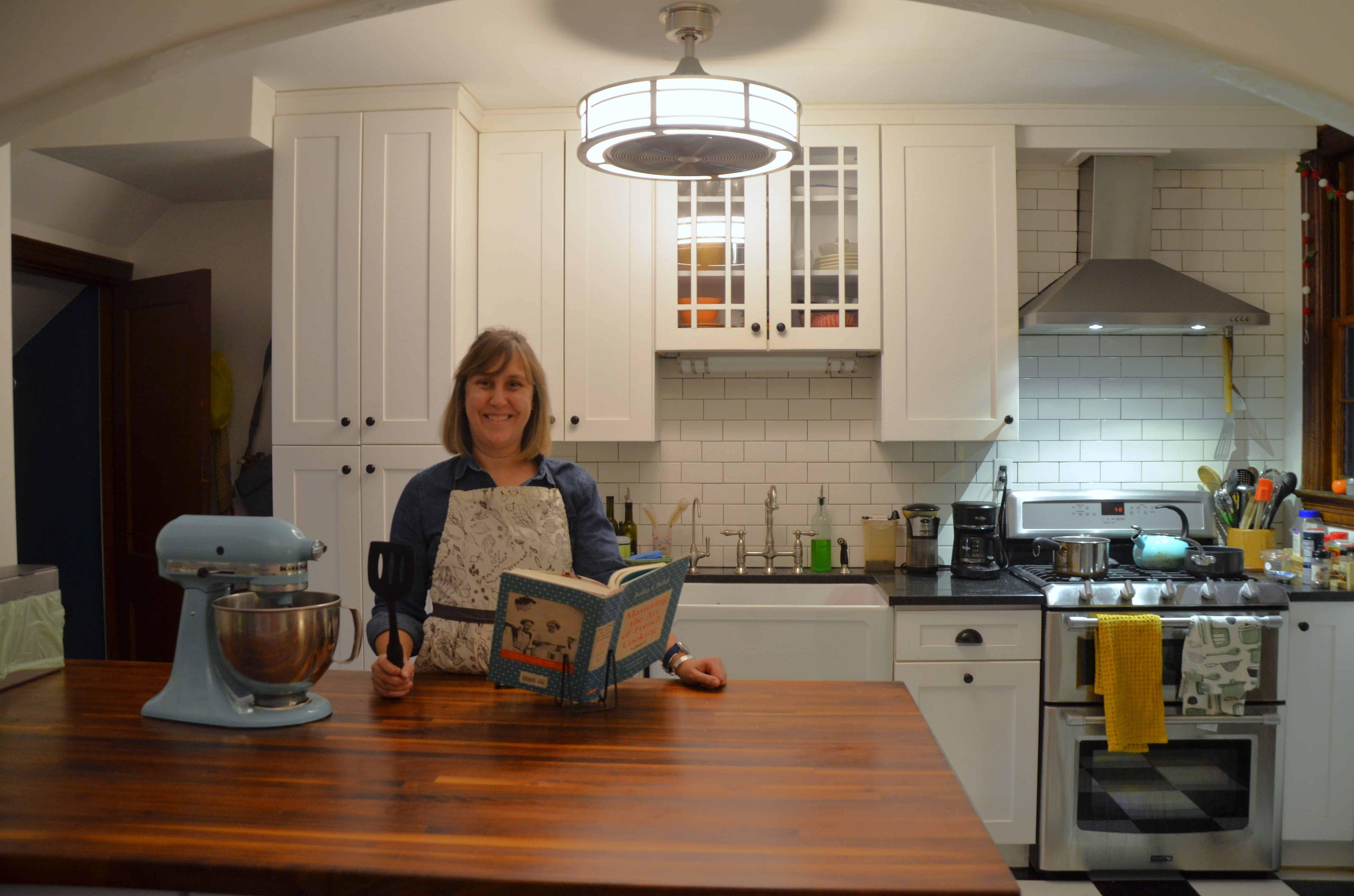 Caroline Smith in her kitchen holding her new book