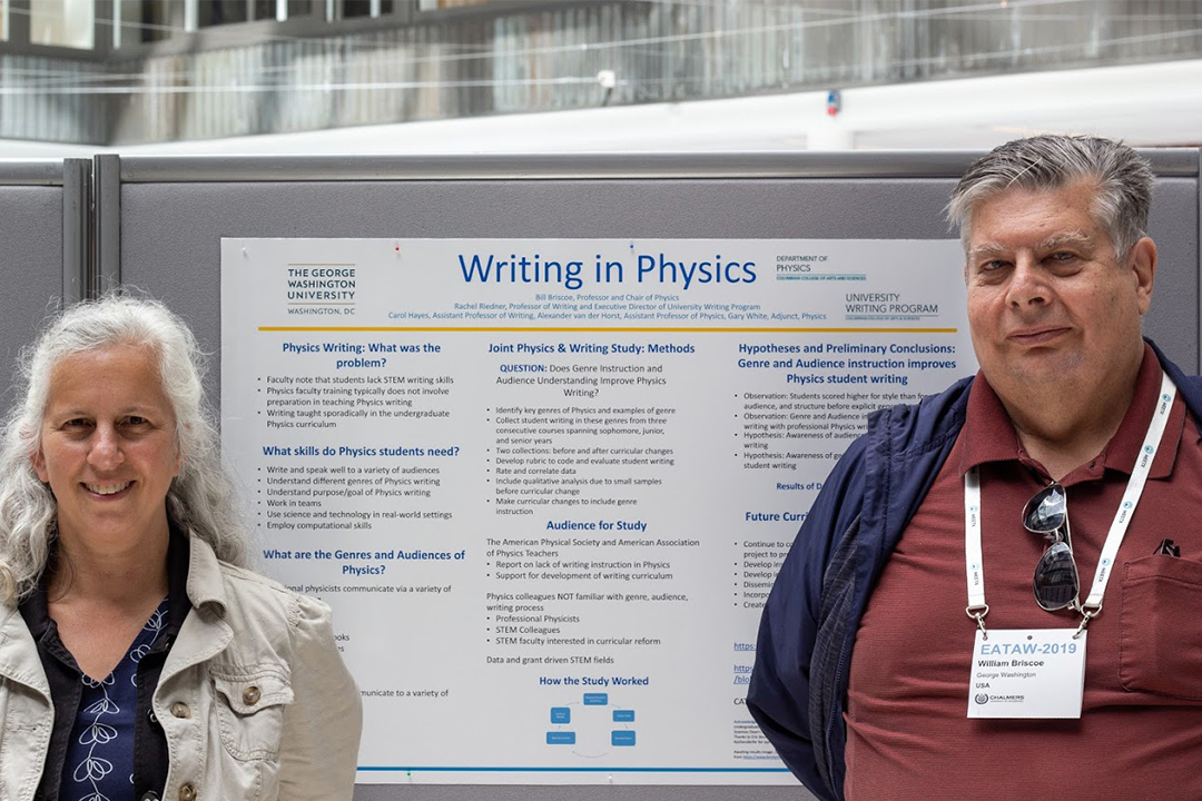 Prof. Rachel Riedner (left) and prof. Bill Briscoe (right) in front of the "writing in physics" poster