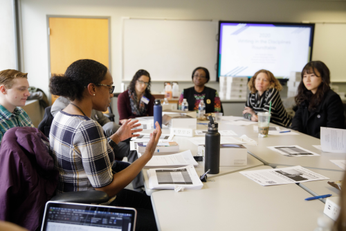 Students and staff discussing at a writing in the disciplines roundtable event