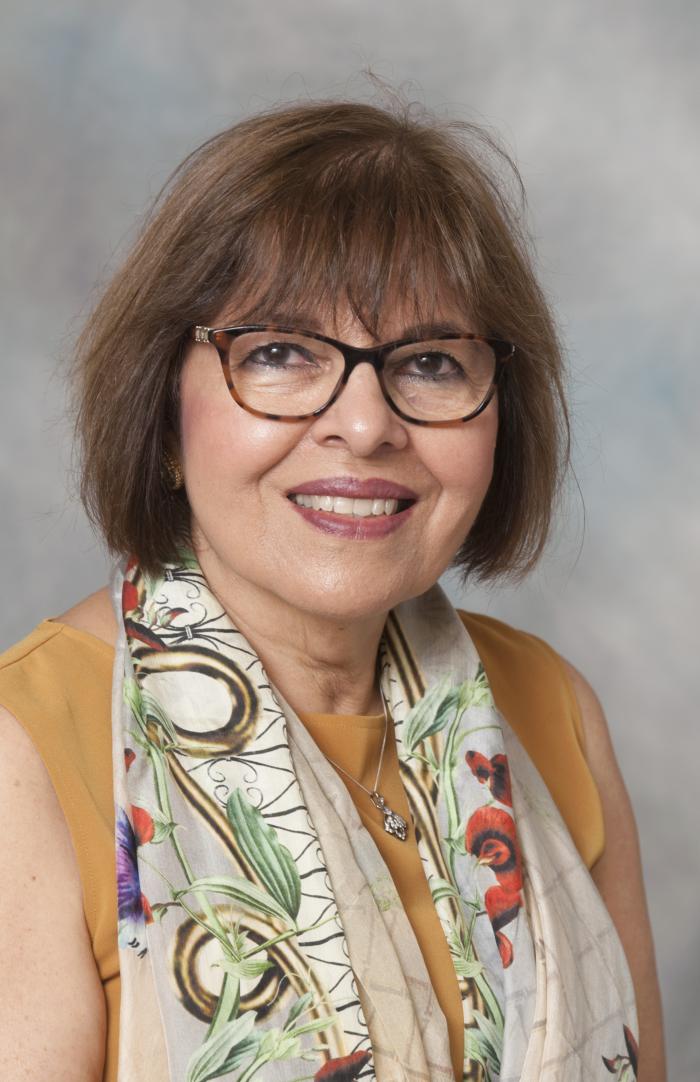 Headshot of Nasreen Abbas against a gray background.