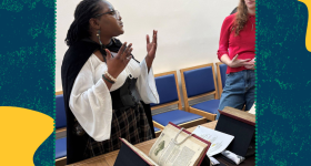 Woman dressed in Shakespearean period clothing talking to student.
